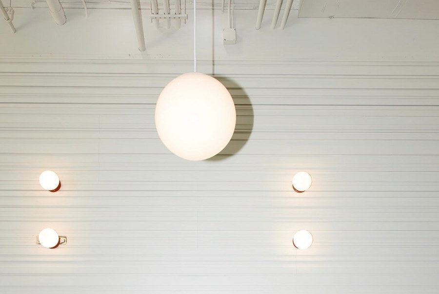 About page mobile hero — salon interior with globe pendants