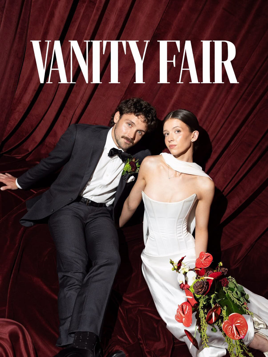 Sara & husband featured in Vanity Fair — corset gown with red anthuriums against red velvet